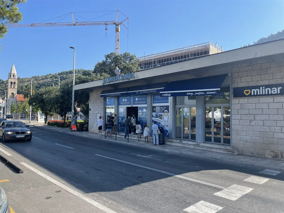 L’ufficio di Jadrolinija nel porto di Gruž a Dubrovnik, con viaggiatori davanti all’ingresso